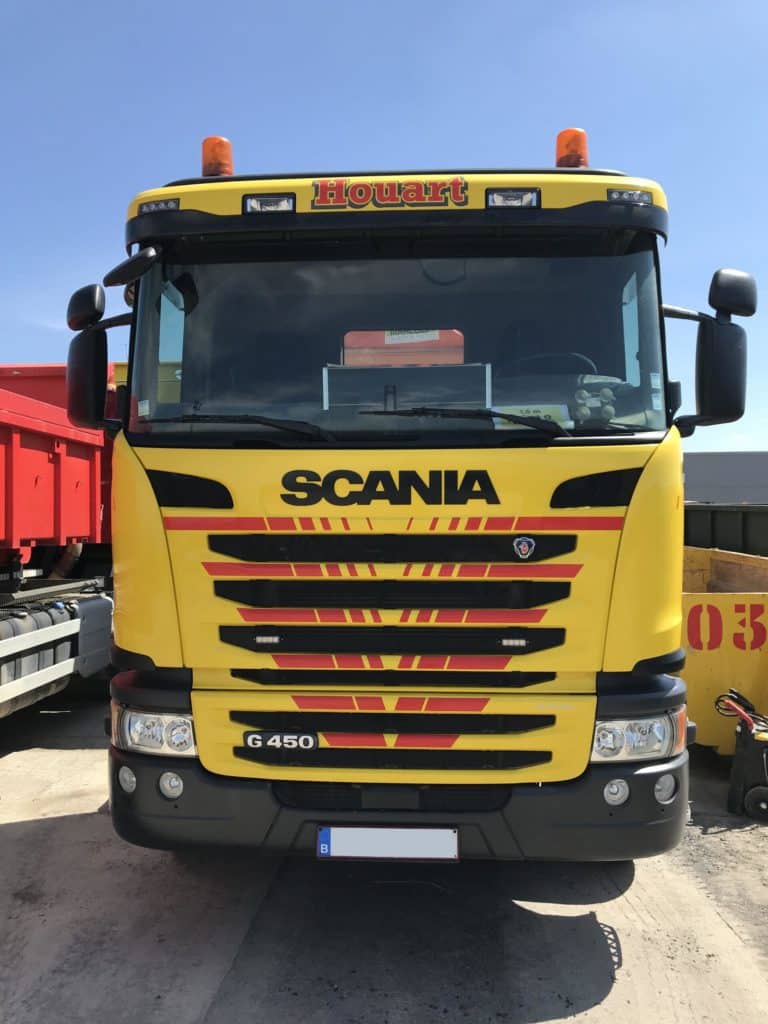Cabine d'un camion jaune Houart Services de la marque Scania vu de face